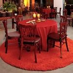 Event furniture display, round table with color coordinated linens, rolled utensils and lit candles